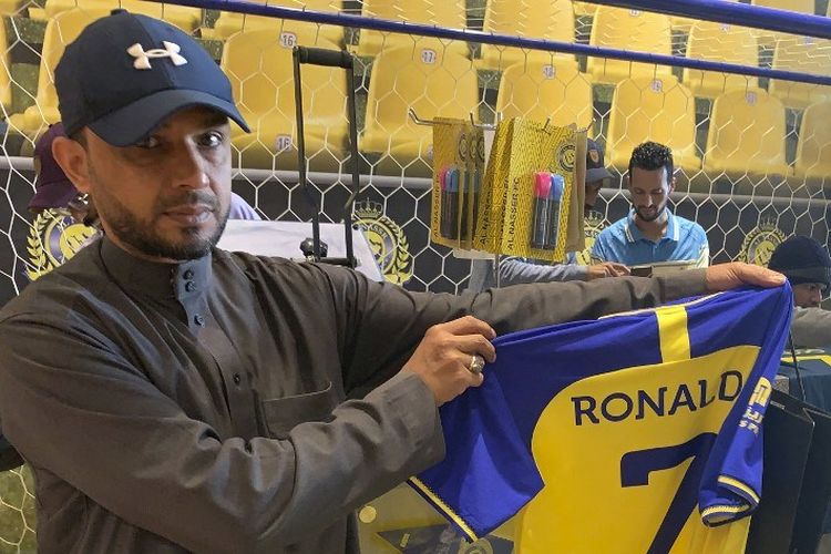 Seorang penggemar memegang kaus bertuliskan nama Ronaldo dan nomor 7 di toko Saudi Al Nassr FC di ibu kota Saudi, Riyadh, pada 31 Desember 2022. - Cristiano Ronaldo menandatangani kontrak dengan Al Nassr dari Arab Saudi pada 31 Desember 2022. Demikian pengumuman klub dalam kesepakatan yang diyakini bernilai lebih dari 200 juta euro. Pemain berusia 37 tahun itu meneken kontrak hingga Juni 2025.