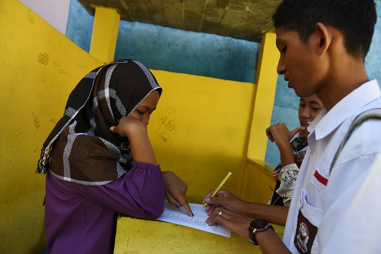 Siswa mandata rekannya saat hari pertama masuk sekolah di SMA PGRI, Palu, Sulawesi Tengah, Senin (8/10). Pihak sekolah melakukan pendataan pada hari pertama sekolah untuk mengetahui jumlah siswa pascagempa dan tsunami.