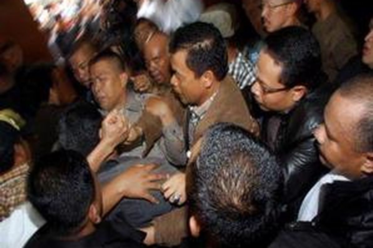 Terdakwa kasus pembunuhan Munir, mantan Deputi V BIN Muchdi Purwoprandjono dengan pengawalan ektra ketat berusaha keluar dari kerumunan massa pendukungnya yang ingin mengucapkan selamat usai mengikuti persidangan dirinya di Pengadilan Negeri Jakarta Selatan, Rabu (31/12). Dalam persidangan Majelis Hakim memvonis bebas karena tidak ada bukti yang menguatkan bahwa terdakwa adalah orang yang menggerakkan terpidana kasus Munir, Pollycarpus, untuk membunuh Munir. 