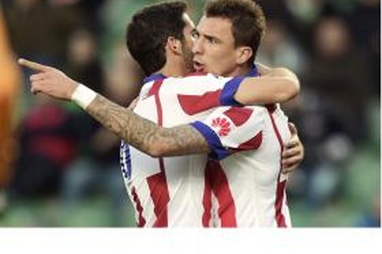 Penyerang Atletico Madrid asal Kroasia, Mario Mandzukic (kanan), melakukan selebrasi bersama gelandang Raul Garcia, setelah mencetak gol ke gawang Elche pada laga Primera Division di Martin Valero stadium di Valencia, Sabtu (6/12/2014).