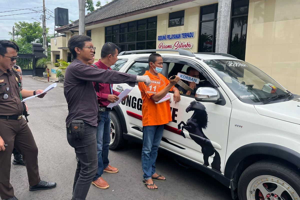 Tersangka ST saat memeragakan aksi pembunuhan terhadap korban SU. Rekonstruksi kasus pembunuhan ini berlangsung di Lapangan Apel Kepolisian Resor Nganjuk, Senin (9/12/2024)