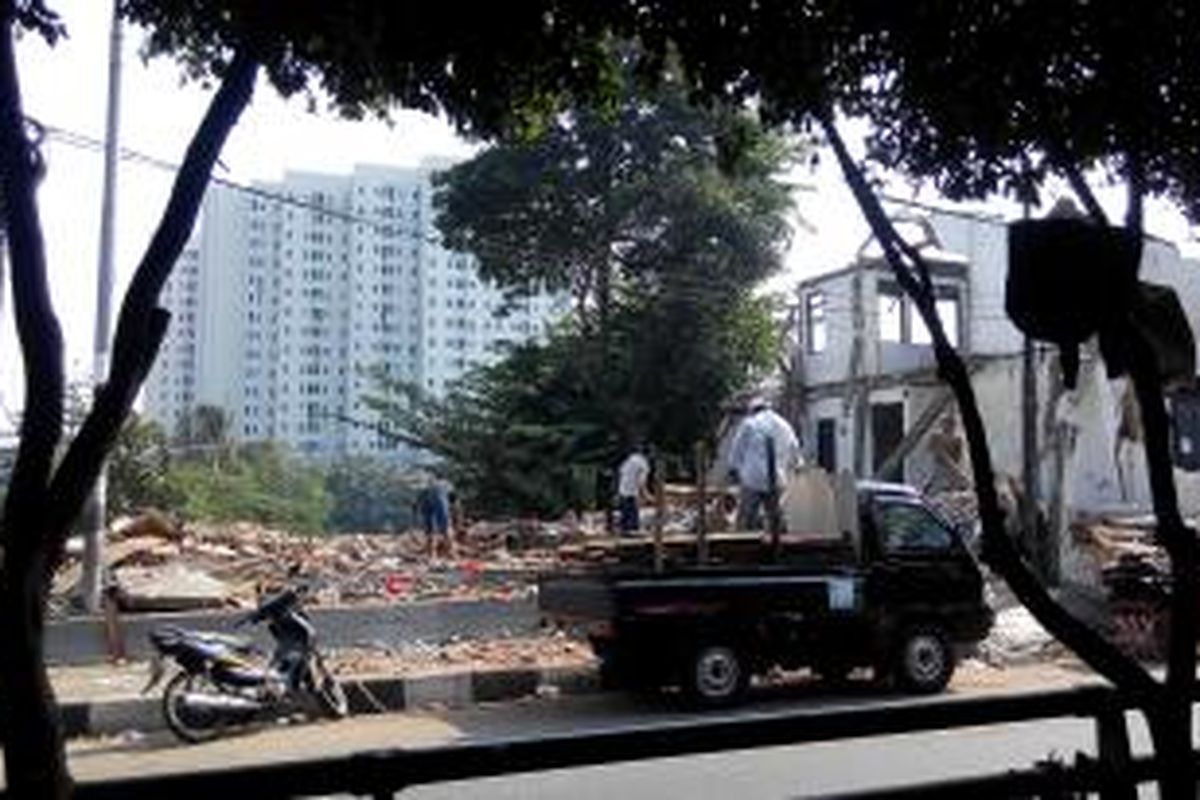 Warga memunguti memunguti kayu dan besi di puing-puing rumah Kampung Pulo, Jakarta Timur, Minggu (23/8/2015).