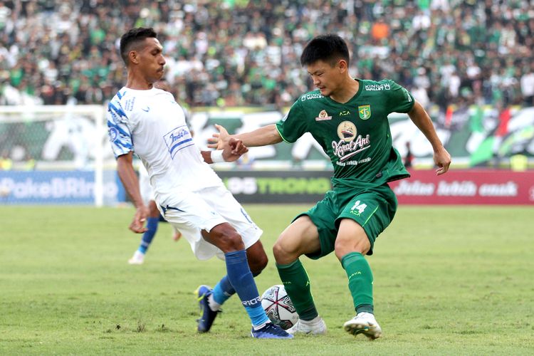 Pemain asing Persebaya Surabaya Sho Yamamoto berebut bola dengan pemain PSIS Semarang Delfin Rumbino saat pertandingan pekan 6 Liga 1 2022-2023 yang berakhir dengan skor 1-0 di Stadion Gelora Bung Tomo Surabaya, Selasa (23/8/2022) sore.