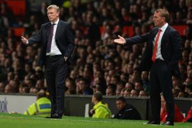 Pelatih Manchester United David Moyes (kiri) dan pelatih Liverpool Brendan Rodgers menyaksikan anak-anak didik mereka bertanding pada laga putaran ketiga Piala Liga Inggris, di Old Trafford, Rabu (25/9/2013).