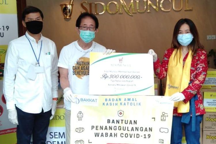 Direktur Sido Muncul Irwan Hidayat (tengah) memberikan bantuan penanggulangan wabah Covid-19 kepada Anastasia Chaterin dari Badan Amal Kasih Katolik (BAKKAT), Rabu (22/4/2020)