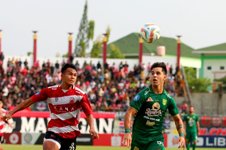 Pemain Madura United Koko Ari berebut bola dengan pemain Persebaya Surabaya Bruno Moreira saat pertandingan pekan ke-12 Liga 1 2023-2024 yang berakhir dengan skor 3-0 di Stadion Gelora Bangkalan, Minggu (17/9/2023) sore.