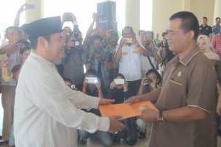 Ketua KPU Ogan Ilir Anahril menyerahkan surat keputusan penetapan kepala daerah Ogan Ilir terpilih ke wakil bupati  terpilih Ilyas Panji Alam.