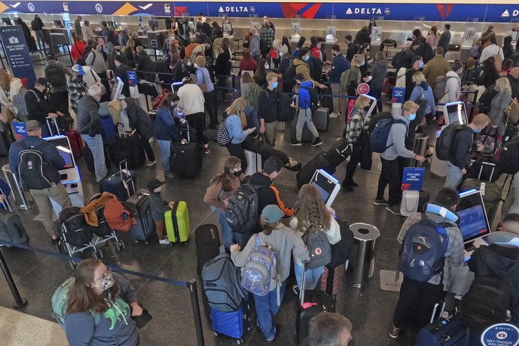 Antrean penumpang pesawat di konter tiket Bandara Internasional Salt Lake City, Kamis (30/12/2021).