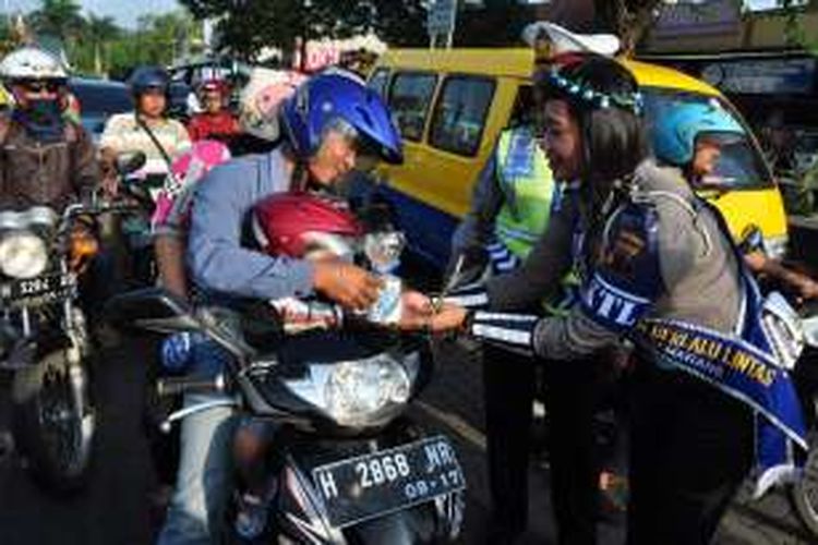  Caption: Aksi simpatik polwan membagikan hadiah kepada pengendara yang tertib berlalu lintas di simpang empat Alun-alun Lama Ungaran, Jl Diponegoro, Ungaran, Kabupaten Semarang, Kamis (17/3/2016) siang.