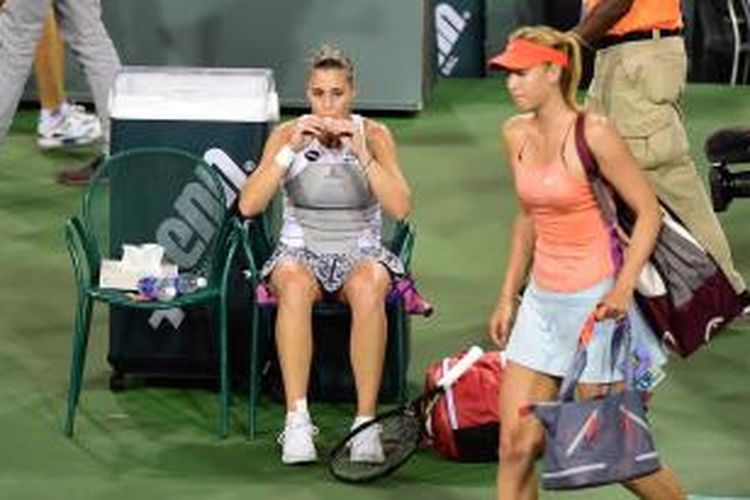 Petenis Italia, Flavia Pennetta, minum saat lawan yang dia kalahkan, Maria Sharapova (Rusia), meninggalkan lapangan usai pertandingan babak keempat BNP Paribas Terbuka di Indian Wells, Selasa (17/3/2015). Pennetta menang 3-6, 6-3, 6-2.