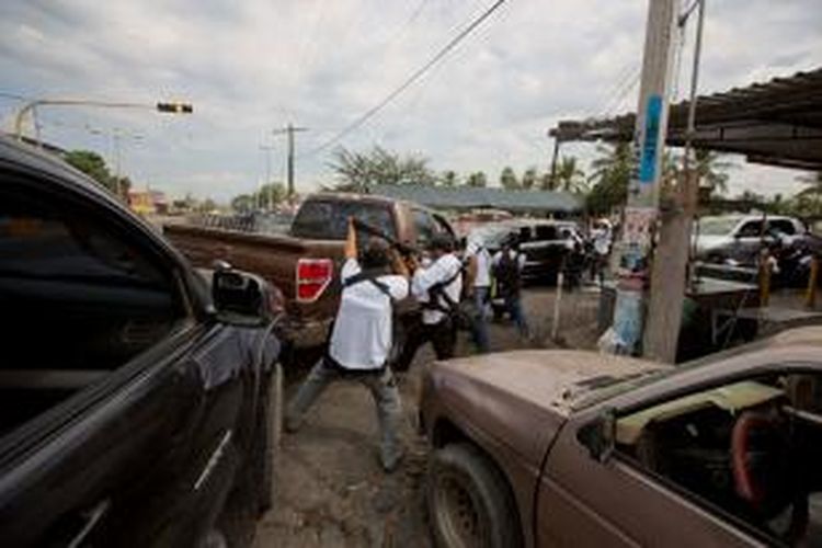 Warga sipil terlibat baku tembak dengan kartel obat bius Knight Templar di kota Nueva Italia, Meksiko, Minggu (12/1/2014). 
