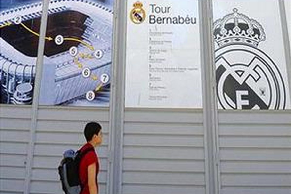 Seorang pria berdiri di depan pintu Stadion Santiago Bernabeu di Madrid. Real Madrid sudah dan masih akan mengeluarkan banyak uang untuk membeli pemain top kelas dunia.