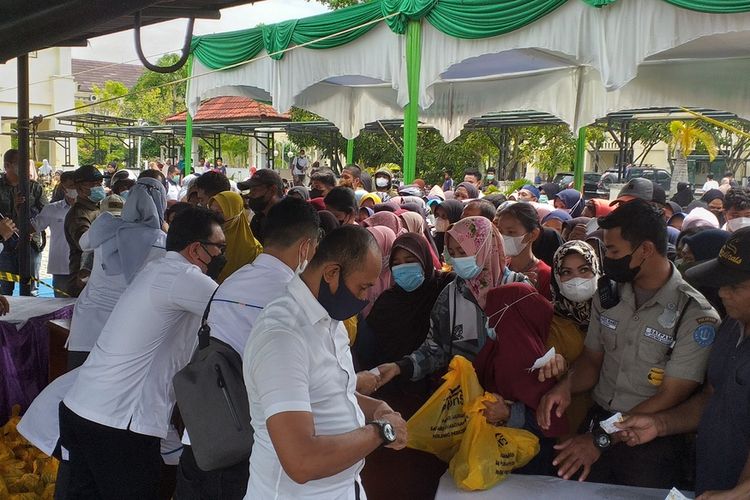 Ratusan warga mengantre membeli minyak goreng dan gula kemasan di pasar murah di kawasan Kantor PTPN V, Kota Pekanbaru, Riau, Selasa (26/4/2022).