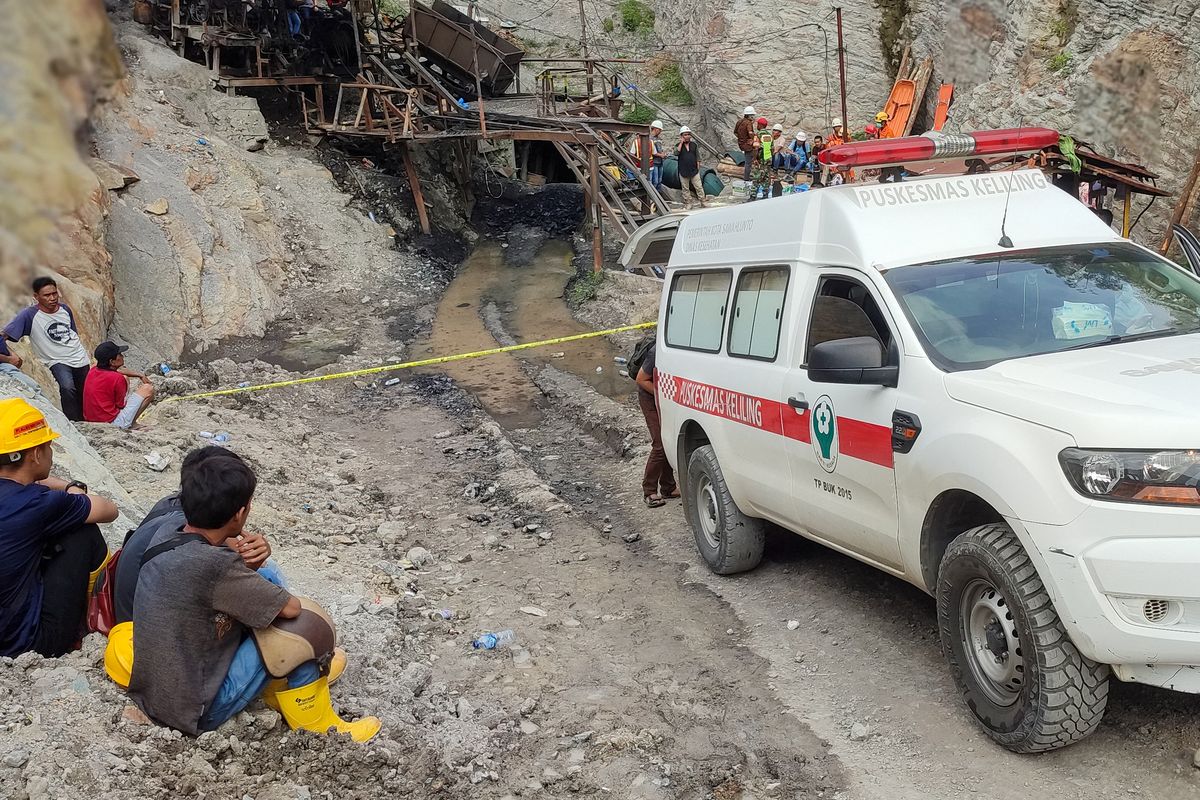 Surviving miners look on as rescue teams evacuate dead and injured victims of a coal mine explosion in Sawahlunto on December 9, 2022. 