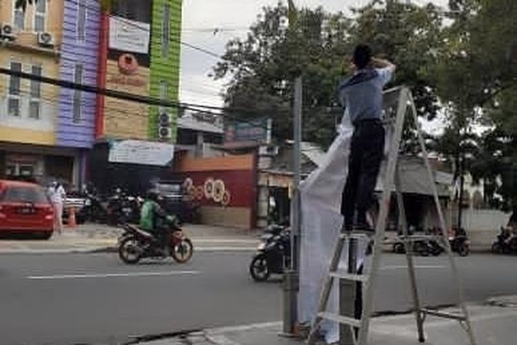 Sebuah bollard di trotoar di Jalan Tebet Raya, Tebet, Jakarta Selatan dipasangi spanduk reklame sebuah klinik kecantikan bernama DL Slim & Skin Care pada Senin (8/3/2021).