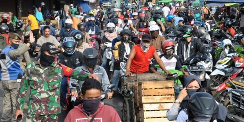 Anggota TNI AD bersama Satpol PP Kota Bogor mengatur arus lalu lintas di kawasan Pasar Anyar, Kota Bogor, Jawa Barat, Senin (18/05) 