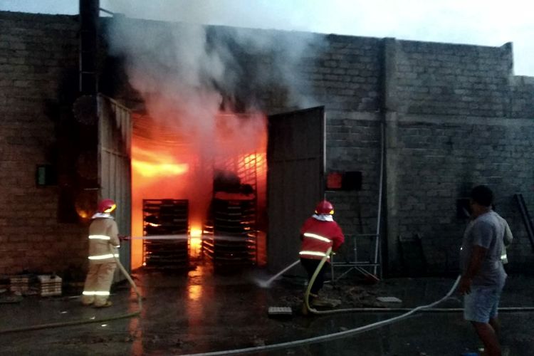 Petugas pemadam kebakaran menyemprotkan air ke arah api yang membakar gudang pabrik egg tray di Desa Ponggok, Kecamatan Ponggok, Kabupaten Blitar, Kamis (5/1/2023)