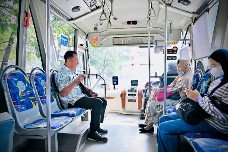 PJ Gubernur Jabar, Bey Machmudin berbincang dengan warga Kota Bandung saat menggunakan angkutan umum BRT menuju Gedung Sate, Kota Bandung, Jumat (22/3/2024).