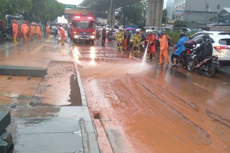 petugas Damkar bersihkan tanah liat di sepanjang jalan Dr Satrio, Kuningan, Jakarta Selatan, Selasa (17/12/2019)