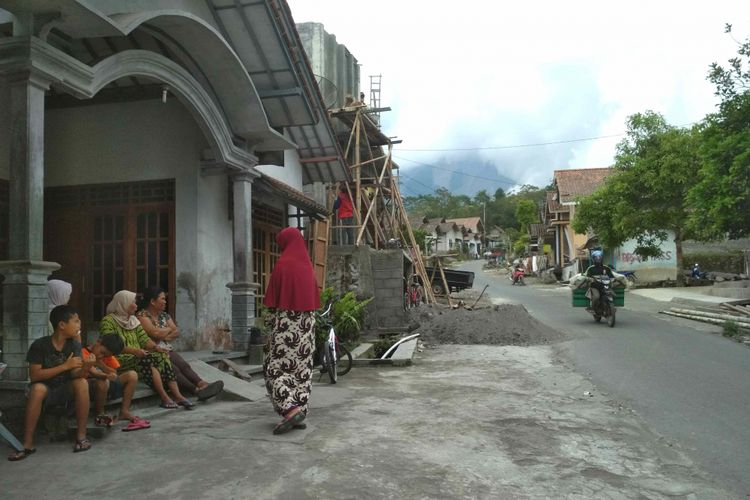 Warga Desa Krijing beraktivitas seperti biasa meski Gunung Merapi sedang bergejolak,  Rabu (23/5/2018). Tampak gunung Merapi tertutup kabut tebal. Desa ini termasuk kawasan rawan bencana (KRB) III erupsi. 