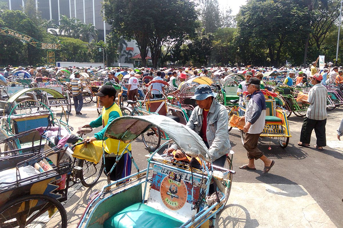 Para tukang becak yang biasa beroperasi di Gresik meninggalkan GOR Tri Dharma, usai menerima bantuan dari PT Petrokimia Gresik.