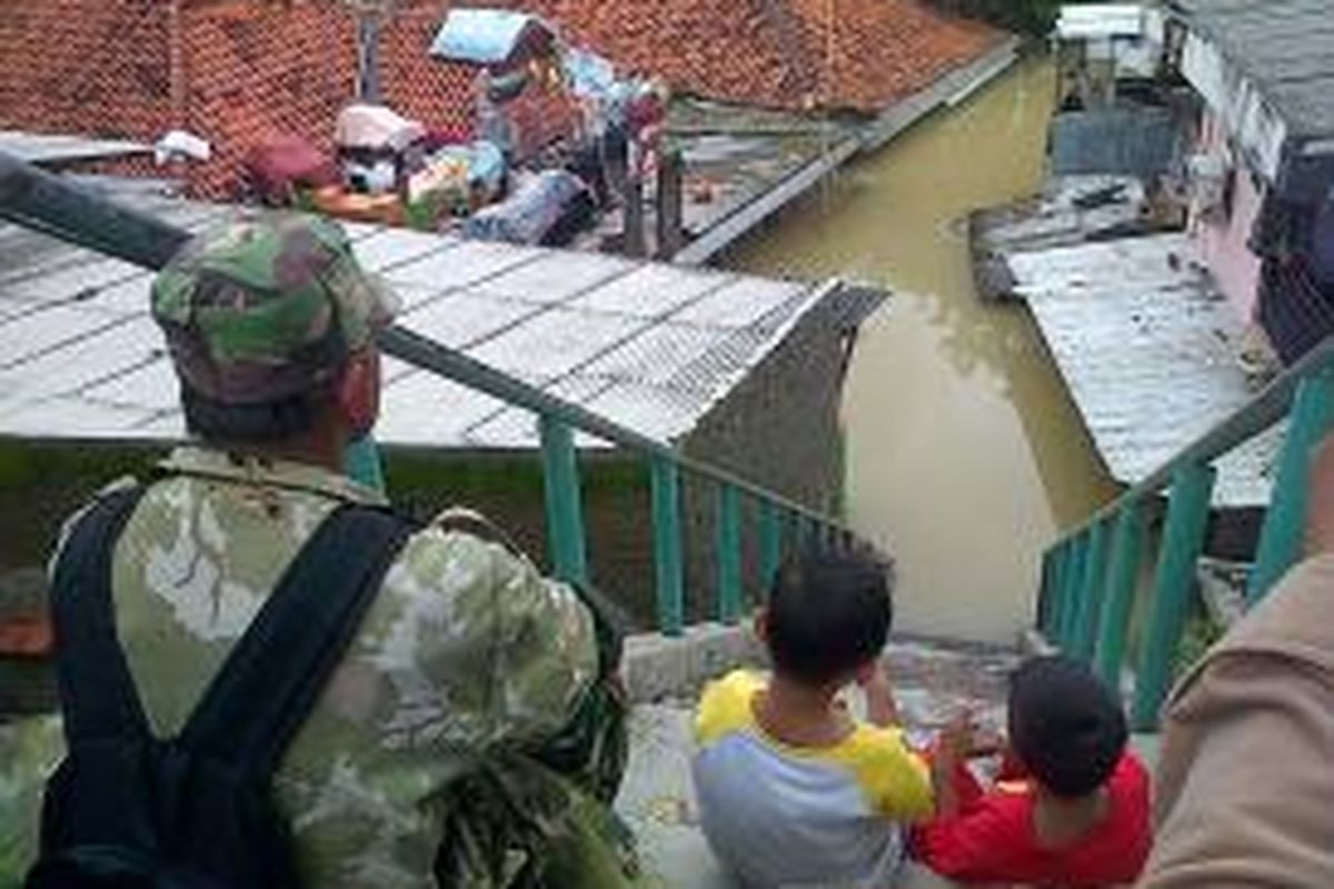 Warga menyaksikan banjir di Cililitan Kecil, Kramat Jati, Jakarta Timur, Senin (20/1/2014). Banjir di tempat ini bertahan selama tiga hari dan mulai berangsur-angsur surut.