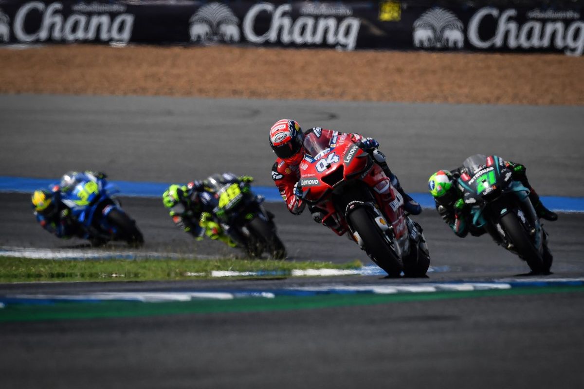 Pebalap MotoGP saat bersaing di sirkuit Buriram, Thailand. (Photo by Lillian SUWANRUMPHA / AFP)