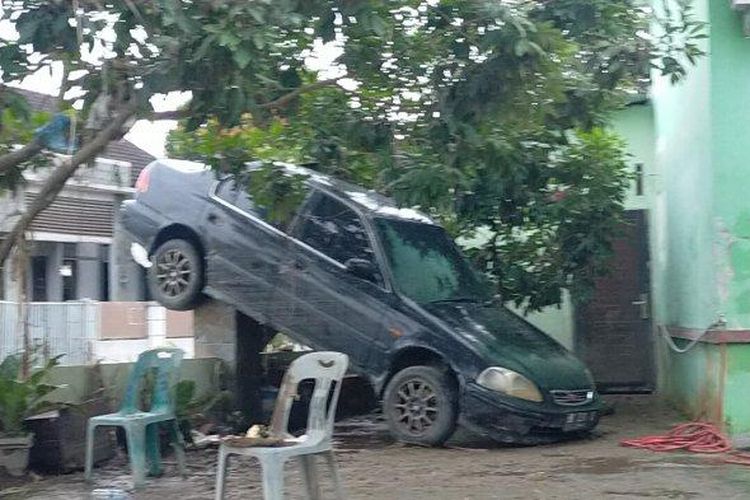 Mobil tersangkut di pagar rumah warga akibat banjir di Komplek Perumahan De Flamboyan, Kecamatan Tanjung Selamat, Medan Tuntungan, Medan, Jumat (4/12/2020). 