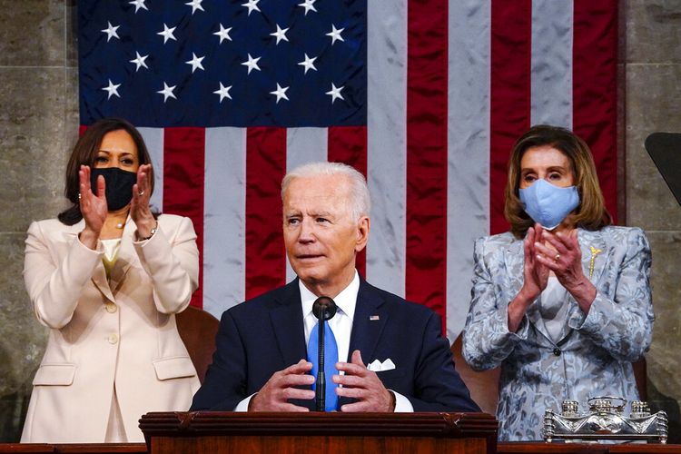 Wakil Presiden Kamala Harris dan Ketua DPR Nancy Pelosi dari California, berdiri dan bertepuk tangan saat Presiden Joe Biden berpidato di sesi gabungan Kongres, Rabu (28/4/2021)