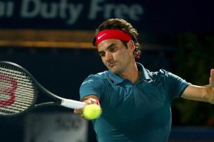 Petenis Swiss Roger Federer mengembalikan bola ke arah Tomas Berdych dari Ceko pada laga final Dubai Duty Free Tennis Championships, Sabtu (1/3/2014). Federer menang 3-6, 6-4, 6-3.