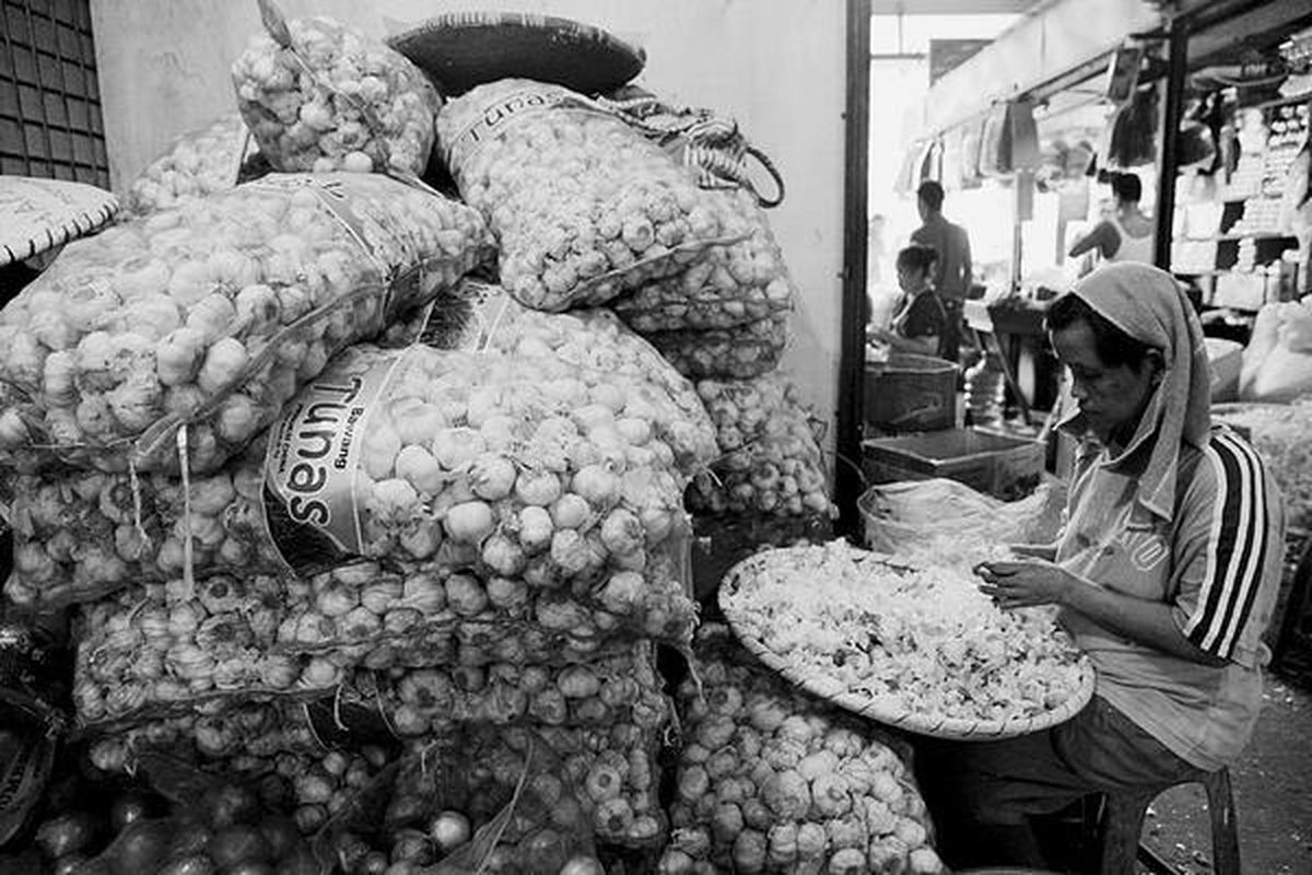 Buruh mengupas bawang putih di Pasar Induk Kramatjati, Jakarta Timur, Selasa (12/3). Harga bawang putih yang terus melambung hingga Rp 44.000 per kilogram tidak hanya dikeluhkan pembeli, tetapi juga para pedagang yang kesulitan mendapatkan pasokan serta kesulitan menjualnya.