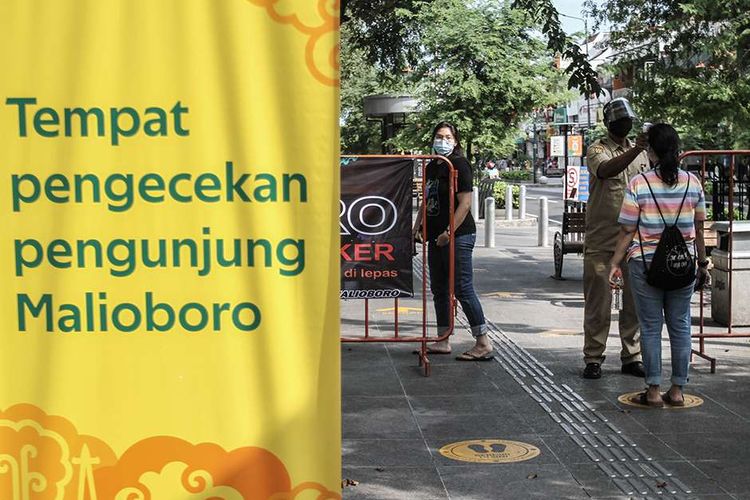 Foto dirilis Rabu (22/7/2020), memperlihatkan petugas Jogoboro memeriksa suhu tubuh pengunjung di Jalan Malioboro, DI Yogyakarta. Pihak pengelola dan penyedia jasa wisata di Yogyakarta mencoba kembali bangkit dengan menerapkan protokol kesehatan Covid-19 secara ketat dan melakukan simulasi untuk membiasakan tatanan era adaptasi kebiasaan baru.