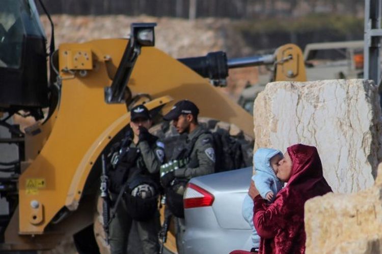 Seorang wanita memeluk seorang bayi ketika ekskavator tentara Israel menghancurkan dua rumah Palestina di daerah Jabal Johar kota Hebron, dekat pemukiman Israel Kiryat Arba, di Tepi Barat yang diduduki, pada 28 November 2022.