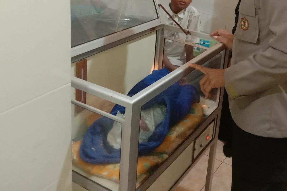 Seorang anggota polisi mengecek bayi berjenis kelamin perempuan yang baru saja ditemukan di teras rumah warga Desa Purwodadi Kecamatan Ringinrejo, Kabupaten Kediri Jawa Timur, Selasa (5/6/2022).