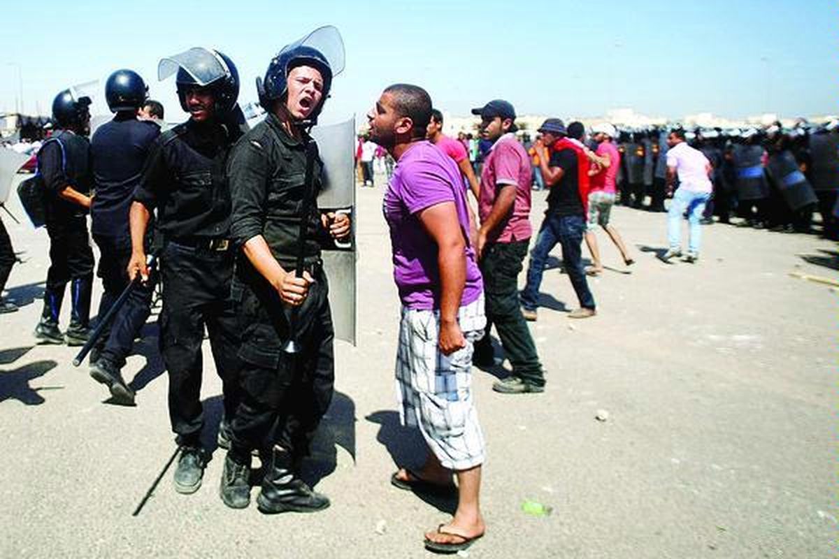 Seorang demonstran beradu mulut dengan polisi Mesir di luar Auditorium Akademi Kepolisian Kairo yang disulap sebagai ruang sidang, Rabu (3/8). Mantan Presiden Mesir Hosni Mubarak, dua putranya, dan tujuh pejabat pemerintah lain pada masanya menjalani sidang pertama dengan tuduhan korupsi dan pembunuhan. Mubarak menyatakan dirinya tidak bersalah dalam sidang yang bersejarah itu.