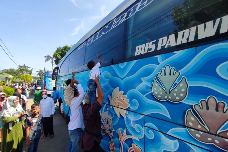 Haikal (3,5) dan Gaisan (4) duduk di atas pundak ayahnya, melambaikan tangan dan mengucap “dadah” kepada neneknya Arini (61) yang sudah di dalam bus rombongan haji. Arini (61), satu dari 162 jemaah haji yang diberangkatkan dari halaman Korem 063 Sunan Gunung Jati Cirebon, Kecamatan Kesambi, Kota Cirebon, Selasa (28/6/2022).