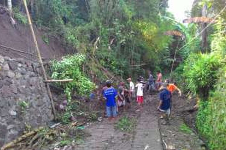 Warga bergotong royong membersihkan material longsor yang menutup akses jalan desa Mejing, Kecamatan Candimulyo, Kabupaten Magelang, Senin (28/11/2016).