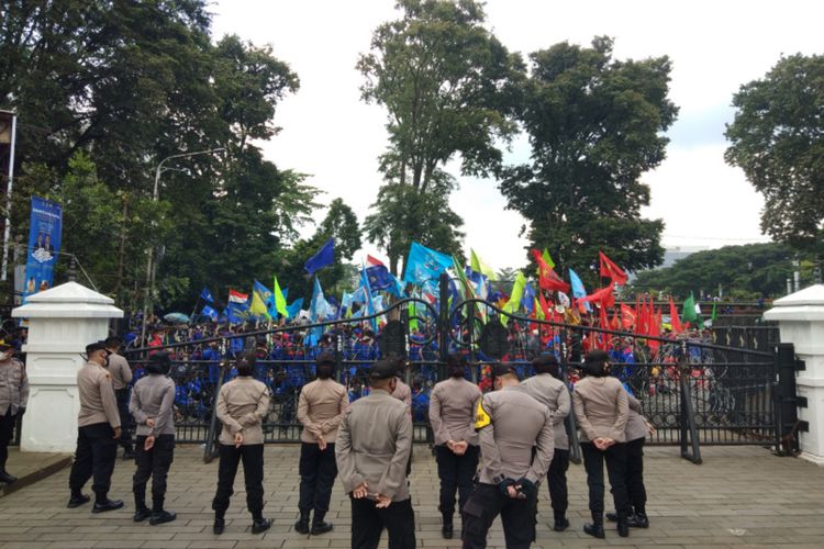 Aparat kepolisian sedang berjaga mengamankan aksi unjuk rasa dari ribuan buruh di Gedung Sate, Jalan Diponegoro, Kota Bandung, Selasa (28/12/2021).