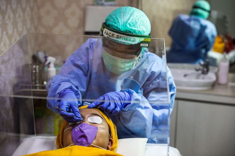 Dokter Spesialis Kulit dan Kelamin, dr. Rahma Evasari menggunakan masker, pelindung wajah serta APD saat melakukan perawatan kulit wajah di RSIA Tambak, Jakarta Pusat, Senin (22/6/2020). Perawatan wajah dengan protokol kesehatan tetap menjadi prioritas klinik kecantikan guna mengantisipasi penularan COVID-19.