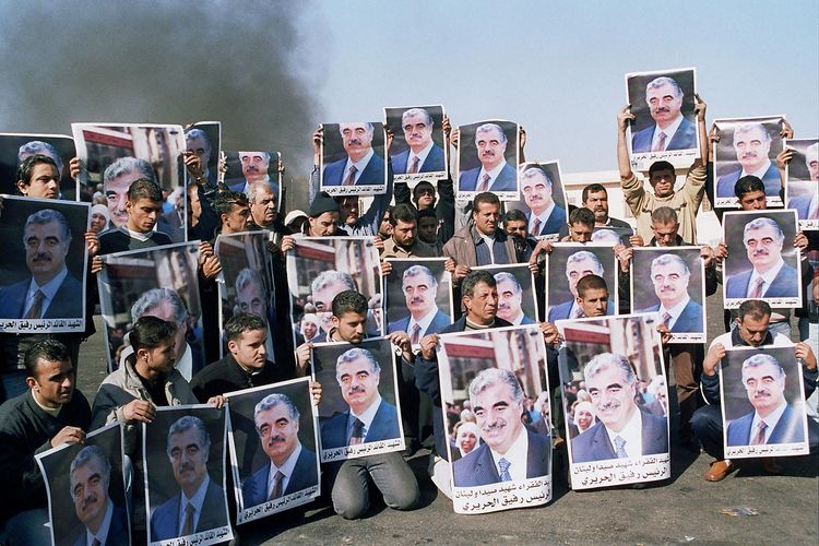 Para pengunjuk rasa memegang poster mantan perdana menteri Lebanon Rafiq Hariri selama parade berkabung di pelabuhan selatan Sidon, kota kelahiran perdana menteri yang terbunuh, 15 Februari 2005. Para pemimpin oposisi anti-Suriah di Lebanon menganggap rezim Suriah dan Lebanon bertanggung jawab atas pembunuhan Hariri di Beirut.