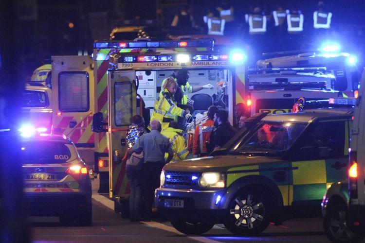 Pasukan keamanan dan petugas gawat darurat menangani para korban serangan teror di London Bridge, Sabtu malam (3/6/2017).
 