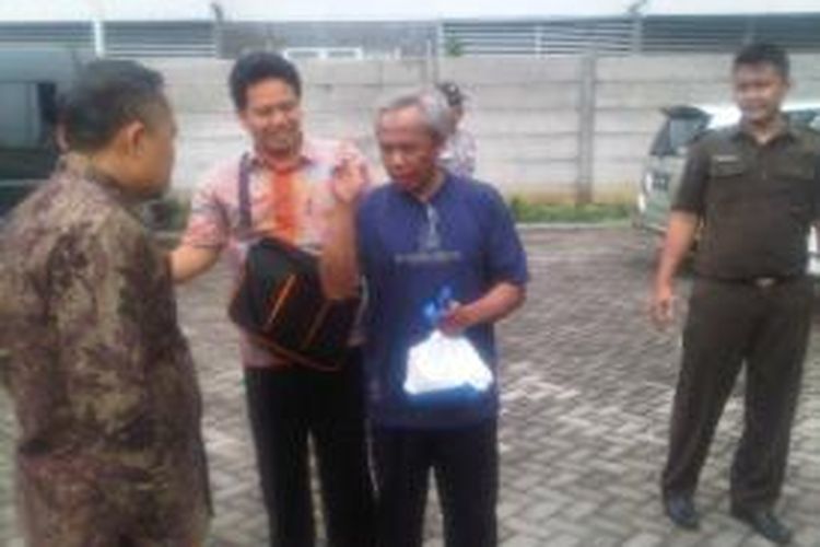 Terdakwa Romli (baju biru) datang di gedung sidang Tipikor Surabaya.