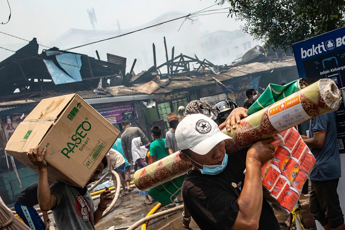 Pedagang mengevakuasi barang dagangannya saat terjadi kebakaran di Pasar Cempaka Putih, Jakarta, Kamis (24/9/2020). Kurang lebih 20 unit mobil pemadam kebakaran dikerahkan untuk memadamkan api, sedangkan penyebab kebakaran masih dalam penyelidikan pihak yang berwenang.