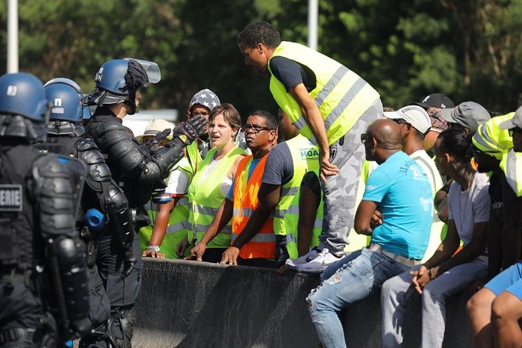Polisi Perancis mencoba berbicara dengan pengunjuk rasa yang memprotes kenaikan harga BBM di kota Sainte-Marie, Reunion, wilayah seberang lautan Perancis, Kamis (22/11/2018).