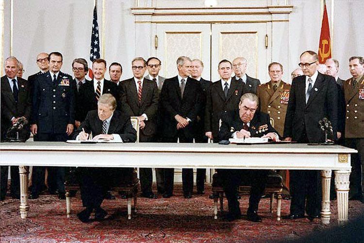 Sekretaris Jenderal Soviet Leonid Brezhnev (kanan) dan Presiden AS Jimmy Carter (kiri) sebagai perwakilan dua negara yang terlibat Perang Dingin sedang menandatangani perjanjian pembatasan senjata SALT II di Wina pada 18 Juni 1979.