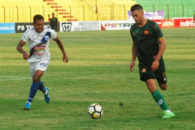 Pemain PSIS Semarang Giiang Ginarsa saat membayangi pemain PS Tira Dzmitry Rekish  