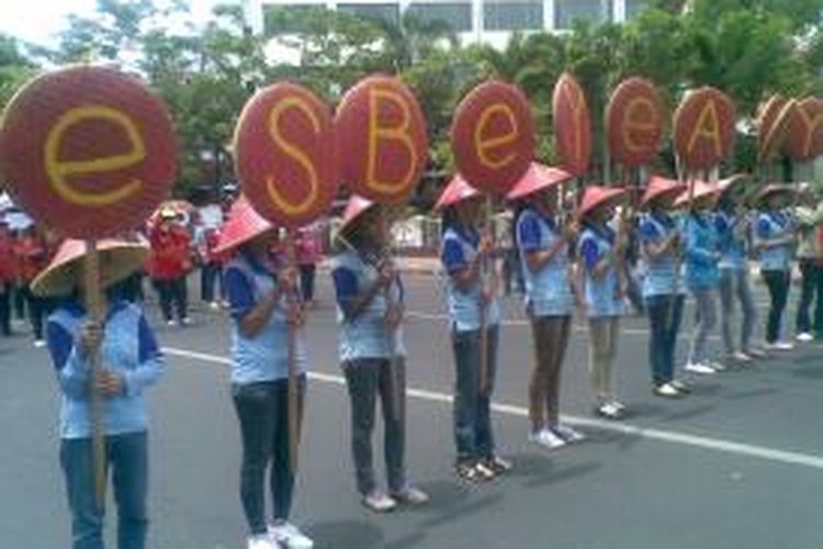 Buruh perempuan membawa nampan bambu bertuliskan huruf ''Esbeye alay''.