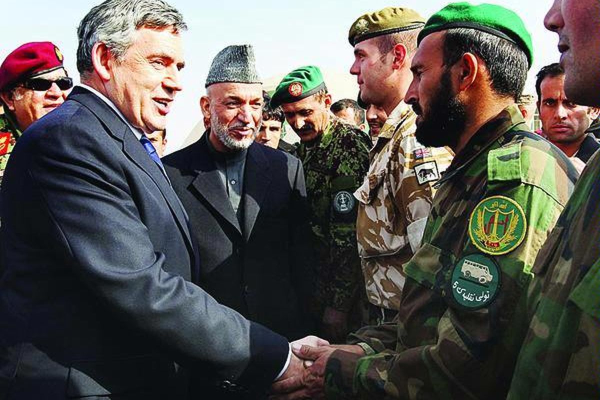Perdana Menteri Inggris Gordon Brown (kiri) dan Presiden Afganistan Hamid Karzai (kedua dari kiri) menemui pasukan Afganistan dan Inggris di pangkalan udara di Kandahar, Minggu (13/12), dalam sebuah kunjungan yang tidak diumumkan sebelumnya.