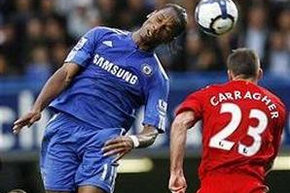 Pemain Chelsea, Didier Drogba (kiri), berusaha menyundul bola mendului pemain Liverpool, Jamie Carragher, dalam duel Liga Inggris di Stamford Bridge, Oktober 2009.