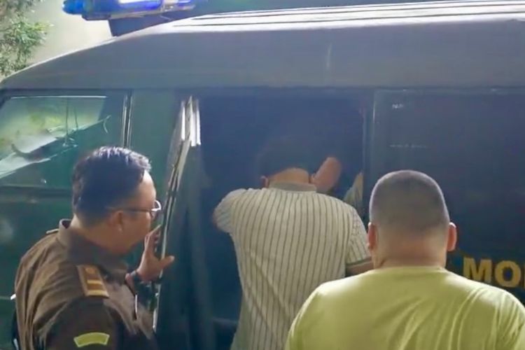 AKP Andri Gustami (kaus bergaris) saat hendak naik ke mobil tahanan Kejari Bandar Lampung untuk ditahan di Rutan Kelas IIA Bandar Lampung, Kamis (5/10/2023).
